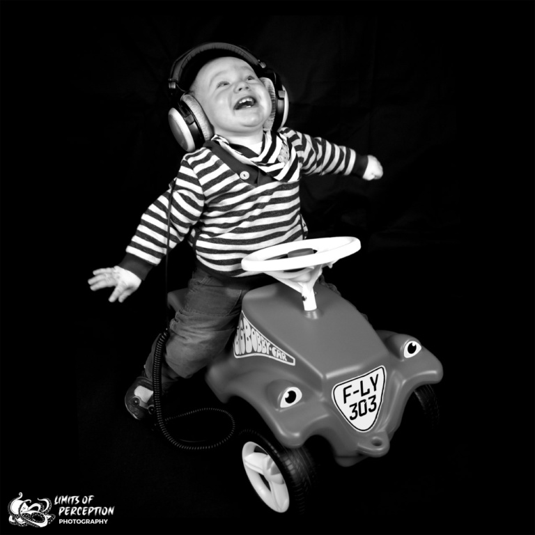 Baby auf Bobbycar mit Kopfhörern